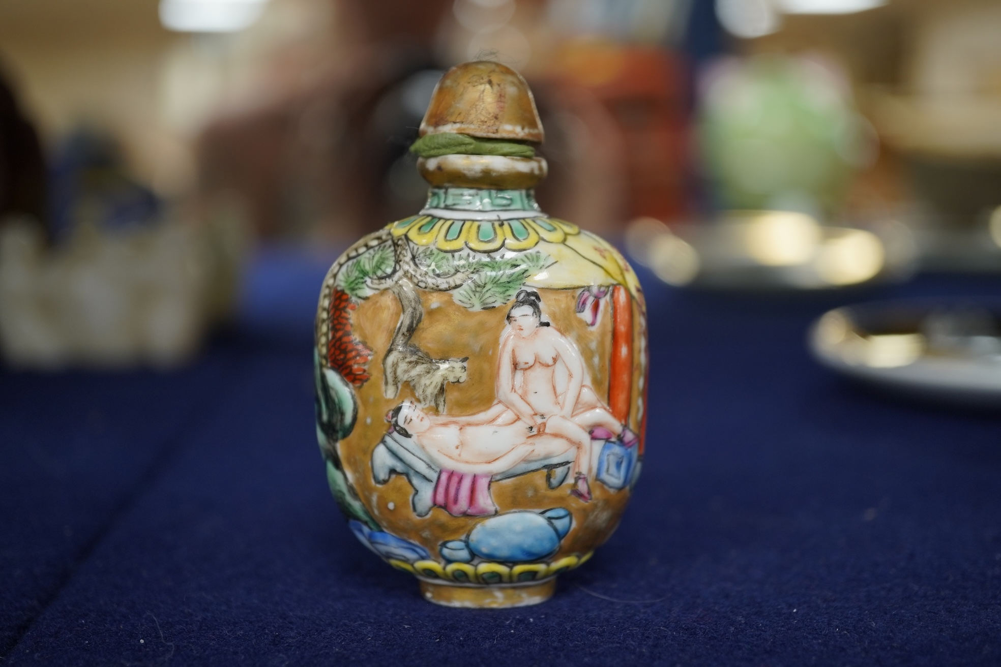 A Chinese enamelled and moulded porcelain erotic subject snuff bottle and stopper, Guangxu mark and possibly of the period, 6.5cm